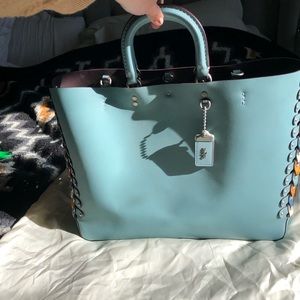 Leather handbag gently used by Coach. Robin blue color with side colors.